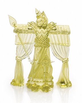 A translucent yellow-green figurine of a robed, horned figure standing between draped curtains.