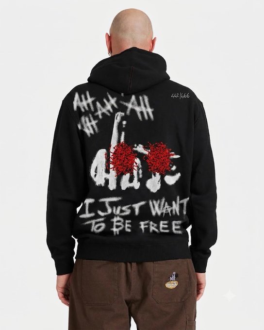 Back view of a person wearing a black hoodie featuring graffiti-style art with the text 'I Just Want To Be Free' and 'LND 1666' printed on the back.