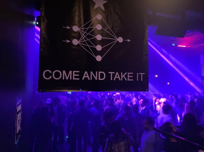 A black banner displaying a neural network diagram and the text "COME AND TAKE IT" hangs over a crowded nightclub bathed in purple lighting.