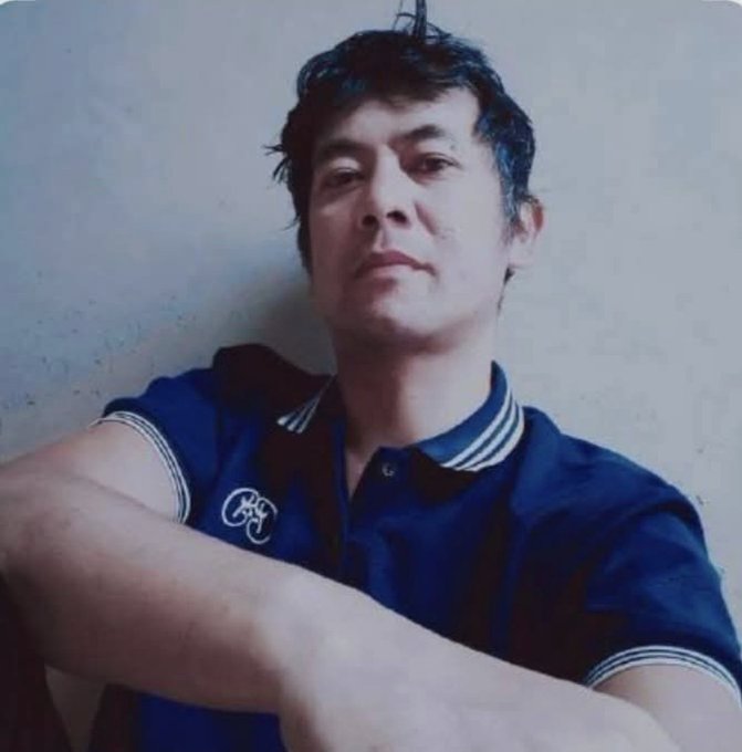 A man wearing a dark blue polo shirt with a "Pi" logo sits with arms crossed against a plain wall, his serious expression conveying quiet confidence that mirrors the post's message of patience and belief in Pi cryptocurrency's underlying technology despite years of doubt and dismissal.