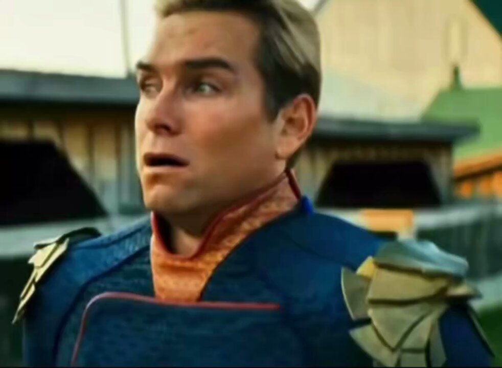 The image features a man with blonde hair wearing a suit and a cape. He appears to be surprised or excited about something, as indicated by his facial expression and body language. In the text that accompanies the image, there are three key pieces of information: Solana is selling for $500 in the city, you could have purchased it at only $65, and the person took a picture.