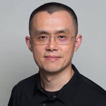 A headshot of a bespectacled Asian man with short hair wearing a black polo shirt, smiling faintly against a gray background. The image likely depicts Changpeng Zhao (CZ), the Binance founder, shown in connection with the post announcing that his net worth has surpassed that of Bill Gates.