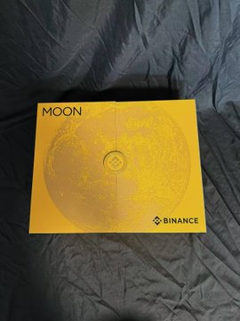 A pair of bright yellow "MOON" sneakers branded with the "BINANCE" logo rests on a dark gray fabric background, visually tying into the post's playful rhyme about BNB, CZ, and Yi He "taking off" with each step.