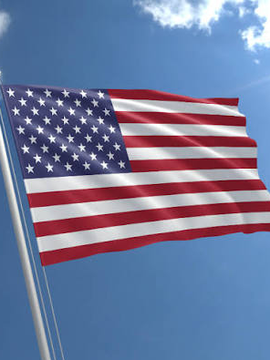 An American flag waves against a blue sky, symbolizing the U.S. focus of a new survey reporting that 18% of Americans own Bitcoin and crypto, with 14% considering themselves knowledgeable in BTC, per the Bitcoin Policy Institute and Cygnal.