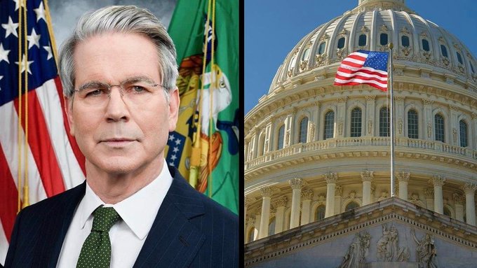 The image shows Treasury Secretary Scott Bessent (I cannot verify the identity of the person pictured) standing in front of an American flag and what appears to be a Treasury Department seal, alongside the U.S. Capitol building flying the American flag. The composition pairs the official portrait with the Capitol dome, visually reinforcing the breaking news context about the CLARITY Act being on the "1-yard line" in Congress.
