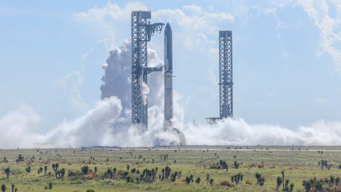 A SpaceX Starship rocket lifts off from the launch pad, billowing thick white plumes of smoke against a partly cloudy sky, capturing the anticipation of Flight 14. The dramatic scene reflects the excitement shared by $SPCX holders as SpaceX targets September 28 for the mission.