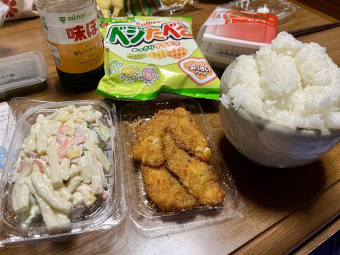 The image shows a table with three plastic containers filled with food, including rice, chicken, and other items such as chips and candy. The containers are placed next to each other, creating an inviting scene for someone to enjoy a meal. A bottle of sauce is also present on the table, adding variety to the dishes. The post about Japanese food suggests that this meal could be from Japan or inspired by Japanese cuisine.