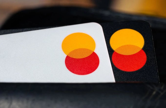 A close-up photograph of two overlapping Mastercard credit cards showing the distinctive yellow and red intersecting circles logo.