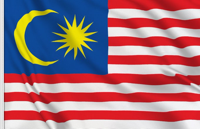 The image shows the national flag of Malaysia, featuring 14 red and white horizontal stripes with a blue canton in the upper left corner displaying a yellow crescent and a 14-pointed star, which aligns with the post highlighting Malaysia's statement about XRP potentially replacing bank deposits in global payments.