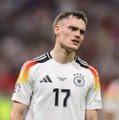 A German national team player wearing jersey number 17 in the white home kit with black, red, and gold accents.