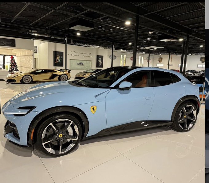 A light blue Ferrari Purosangue SUV displayed in a luxury car showroom, with a gold Lamborghini and other high-end vehicles visible in the background.