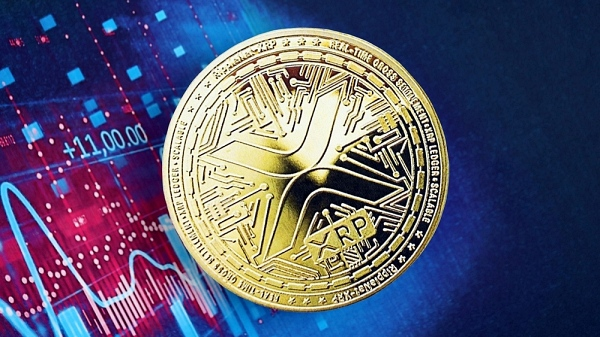 A close-up of a gold XRP cryptocurrency coin resting on a colorful background displaying a stock chart with a value of '+11,000.00'.