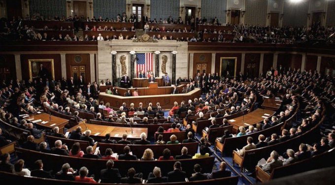 A wide-angle view of the U.S. House of Representatives chamber during a joint session, with members seated and an American flag displayed behind the speaker's rostrum.