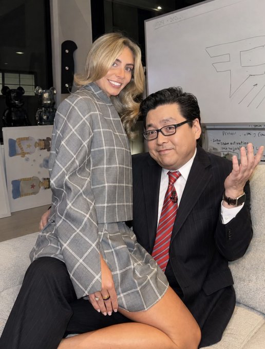 The image features a man wearing a suit and tie, sitting next to a woman who is dressed in a plaid shirt and skirt. They are both smiling at the camera. The background of the photo includes a whiteboard with some writing on it, as well as a painting hanging on the wall behind them. There's also an interesting detail that says "ETH IS ABOUT TO MOON". This phrase seems to be related to the content of the image or could be part of a conversation between the man and woman.

The post is about a new movie called "ETH IS ABOUT TO MOON", which has been released on DVD. The title of the movie can be seen in the image, along with some text that reads "Focus on what is in the image and how it relates to the post".