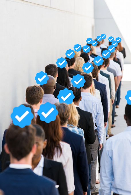 A crowd of people seen from behind, with blue Twitter-like verification checkmarks floating above their heads, illustrating the concept of mass verification or bot accounts.