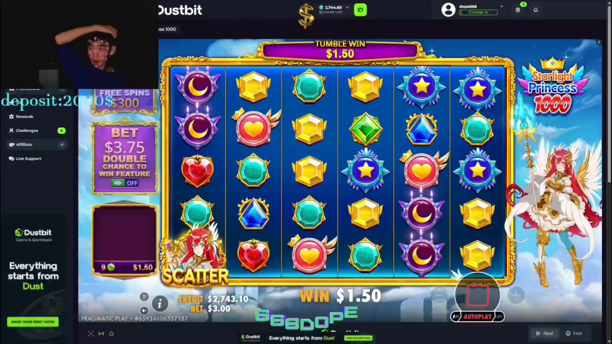 The image shows a casino game display with various colorful symbols and images of characters, including a woman wearing a crown and wings. The background features a blue sky with clouds. The text on the screen reads "Justbit", which suggests that this is an online gaming platform or gambling site.