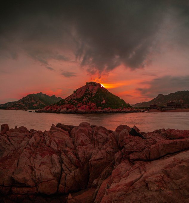 A dramatic sunset casts fiery red and orange hues over rocky coastal terrain, with the sun peeking just behind a rugged hilltop.

This image evokes themes of striking natural beauty and the golden hour "winner" feeling—aligning with the post's giveaway by capturing a visually stunning, high-value scene reminiscent of winning moments.