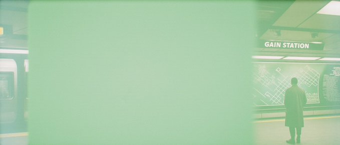 A subway station scene bathed in a green tint shows a man in a long coat standing before a wall display labeled "GAIN STATION," evoking the irony of waiting for external validation when true fulfillment comes from the art one collects. The muted, dreamlike atmosphere reinforces the collection's theme of finding meaning in art amid societal "degeneracy."