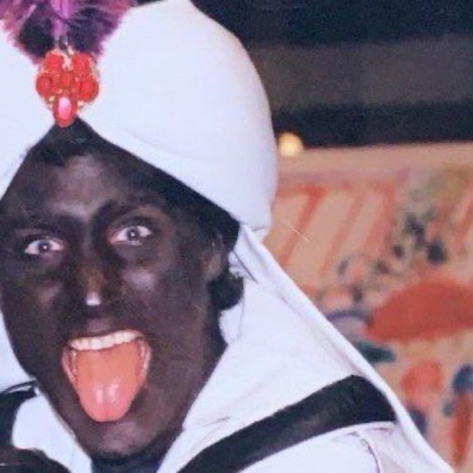 The image features a person wearing a white turban, with their tongue sticking out playfully. They are also wearing black makeup, which adds an interesting contrast to the overall appearance. The background of the photo includes a painting that appears to be colorful or vibrant in nature. The caption "Rotating some hype profit into zec here gn" suggests that there might be a connection between the person's appearance and the content of the post on social media platforms, possibly related to a product or service being advertised.