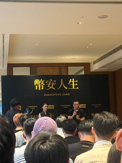 A crowd gathers at a press event for "常人安" (Changpeng Zhao), featuring prominent displays of "CHANGPENG ZHAO" branding and a speaker addressing attendees on stage. The scene connects to the post's reference to a runner wallet address (0x152c82e0d432744703ec29891b86285ec76f7777), suggesting this is a crypto-related appearance by the Binance founder where such on-chain addresses would be relevant.