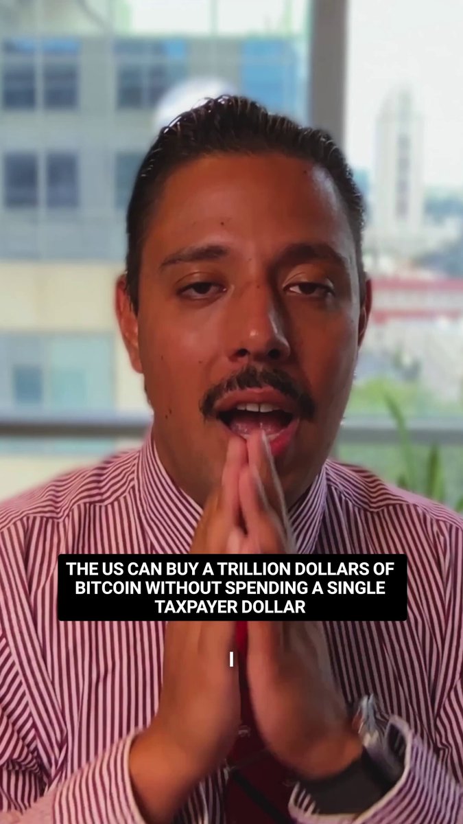 In the image, there's a man wearing a red shirt with his hands clasped together while looking at the camera. The caption below him reads "The US Can Buy a Trillion Dollars of Bitcoin Without Spending A Single Taxpayer Dollar". This statement is related to the content in the image as it suggests that the man might be discussing or promoting the idea of investing in Bitcoin, which is a digital currency.