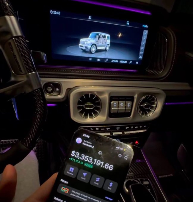 A hand holds a smartphone displaying a Robinhood portfolio worth **$3,353,191.66 (+$77,163.10 / +2.34%)** in front of a luxury Mercedes-Benz G-Wagon's ambient-lit dashboard, capturing the "POV: You locked in" moment of flexing wealth inside a high-end ride.