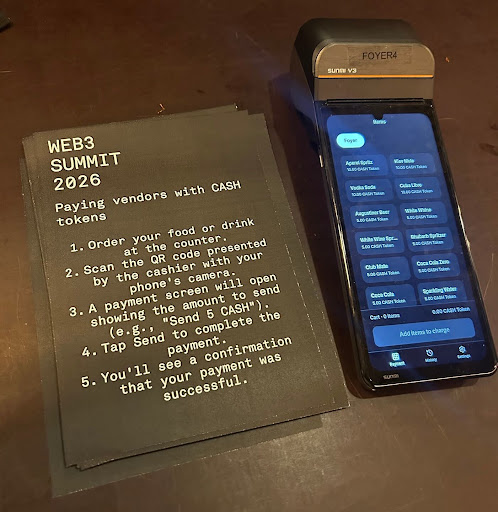 A photo of a WEB3 SUMMIT 2026 printed instruction sheet titled "Paying vendors with CASH tokens" next to a Foyer4 Sunmi V3 POS device displaying a menu of drink items.