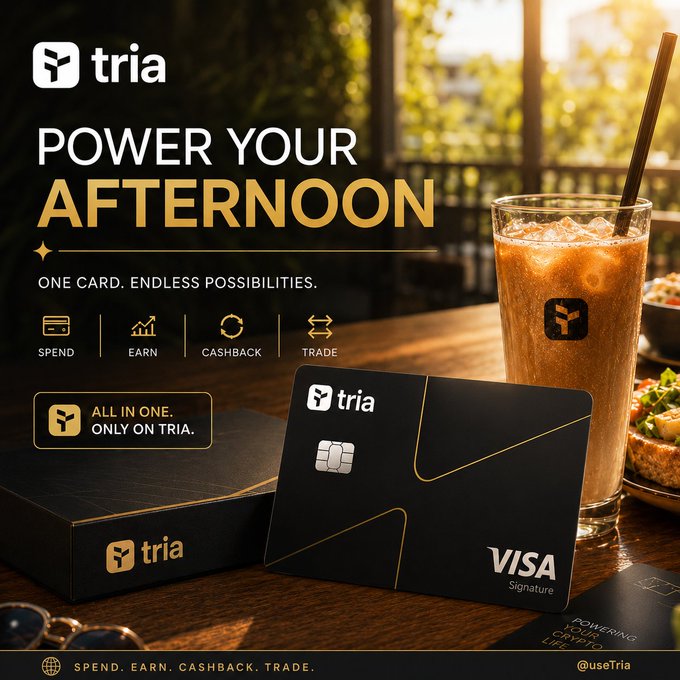 The image features a black Tria credit card with a Visa signature, placed next to a glass of coffee or tea sitting on top of a table. The text in the image suggests that the card can be used for daily transactions, which implies that users should focus on using it as part of their everyday financial routine rather than just holding onto it like a physical cash or checking account.