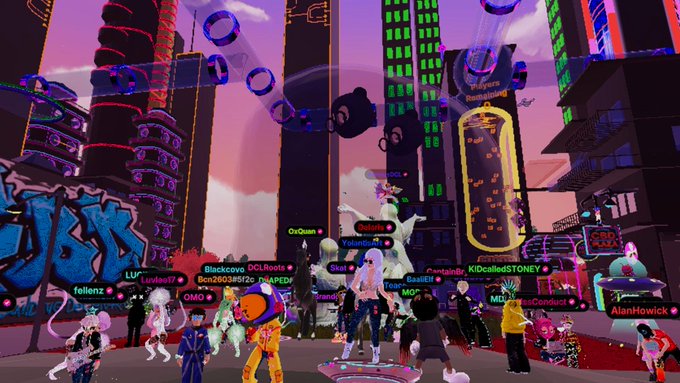The image features a group of people standing around, with some wearing party hats and others dressed in casual clothes. The scene takes place in an urban setting, possibly a city street or plaza, as indicated by the presence of buildings and neon lights. A large banner is visible in the background that reads "CBD Plaza vibes anniversary pants on @CBDecentraland". This suggests that the image might be related to a special event or celebration at the CBD Plaza area.