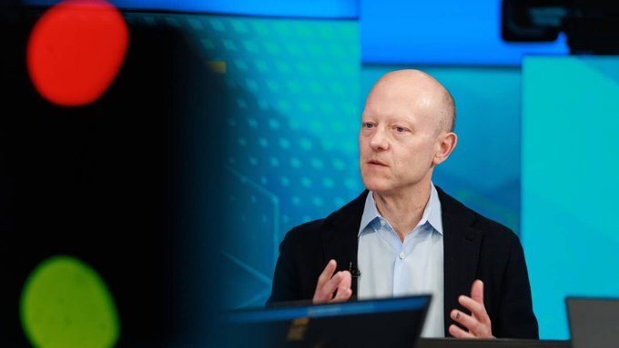 A bald man in a dark suit and light blue shirt gestures while speaking on a financial news set with a blue-toned background, likely discussing Binance's $100 million investment in Circle. The image, though not showing any visible text or logos, visually accompanies an article about the major crypto investment deal.