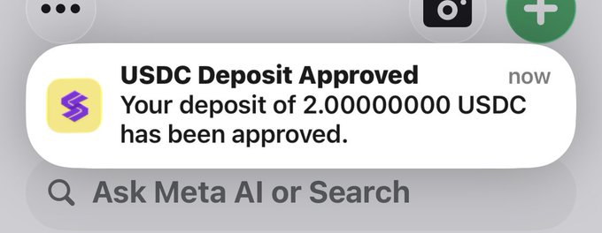 A mobile phone notification on an iOS device reading 'USDC Deposit Approved' stating 'Your deposit of 2.00000000 USDC has been approved,' with the 'Ask Meta AI or Search' bar visible below.