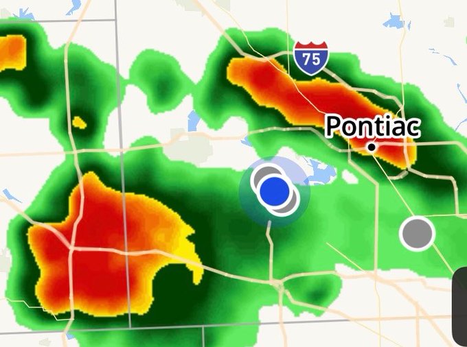 A weather radar map shows severe storm activity near Pontiac with intense red and orange precipitation cells, a blue location marker, and the I-75 highway visible on the display.