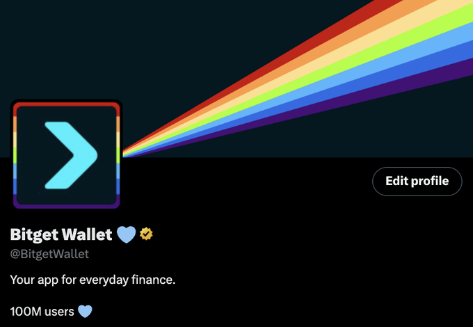 The image shows the Bitget Wallet Twitter profile featuring a dark banner with a rainbow streaming from the profile picture—a blue arrow/chevron icon—against a dark teal background. The caption "What can you find at the end of a rainbow?" ties in with the rainbow leading viewers' eyes to the Bitget Wallet branding, suggesting the wallet app is the "pot of gold" at the rainbow's end, while the profile notes "100M users" and "Your app for everyday finance."