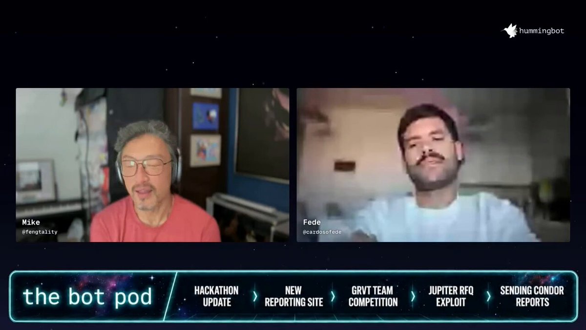 In the image, there are two men sitting next to each other in front of a computer screen with their faces displayed on it. They appear to be on a video call or participating in an online meeting. The background features various elements such as pictures and logos related to technology. One logo is located above the two men's heads, while another one is placed directly below them. There are also some other texts present in the image which seem unrelated to the main focus of the photo – the computer screen displaying the faces of the two men.
