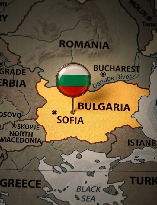 A glossy Bulgarian flag pin marks the country on a map highlighting Sofia, Bucharest, and the Danube River, with the Black Sea visible to the south. The image visually anchors the news that Bulgaria is advancing legislation to require crypto exchanges to disclose user transaction records and personal information.