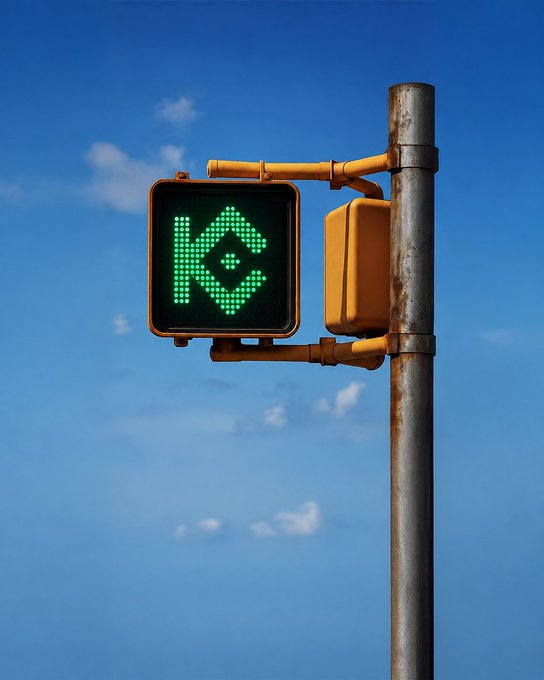 A traffic light against a blue sky displays the KuCoin logo in green instead of a standard signal, cleverly reinforcing the post's message that "this one's telling you to go" toward the KuCoin exchange.
