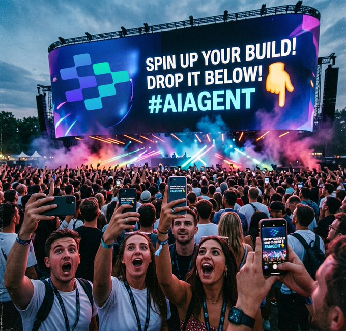 A concert scene with a large crowd cheering while holding up phones, facing a massive LED screen displaying 'SPIN UP YOUR BUILD! DROP IT BELOW! #AIAGENT' next to a pointing hand emoji.