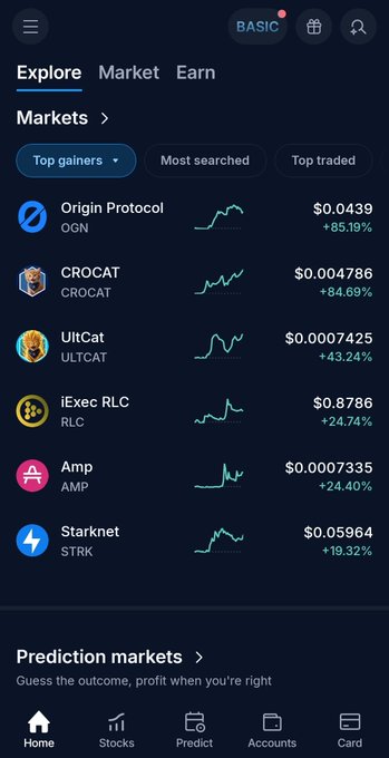 A cryptocurrency trading app screen showing the 'Markets' tab with top gainers including Origin Protocol (OGN) at +85.19%, CROCAT at +84.69%, UltCat at +43.24%, iExec RLC at +24.74%, Amp at +24.40%, and Starknet (STRK) at +19.32%.