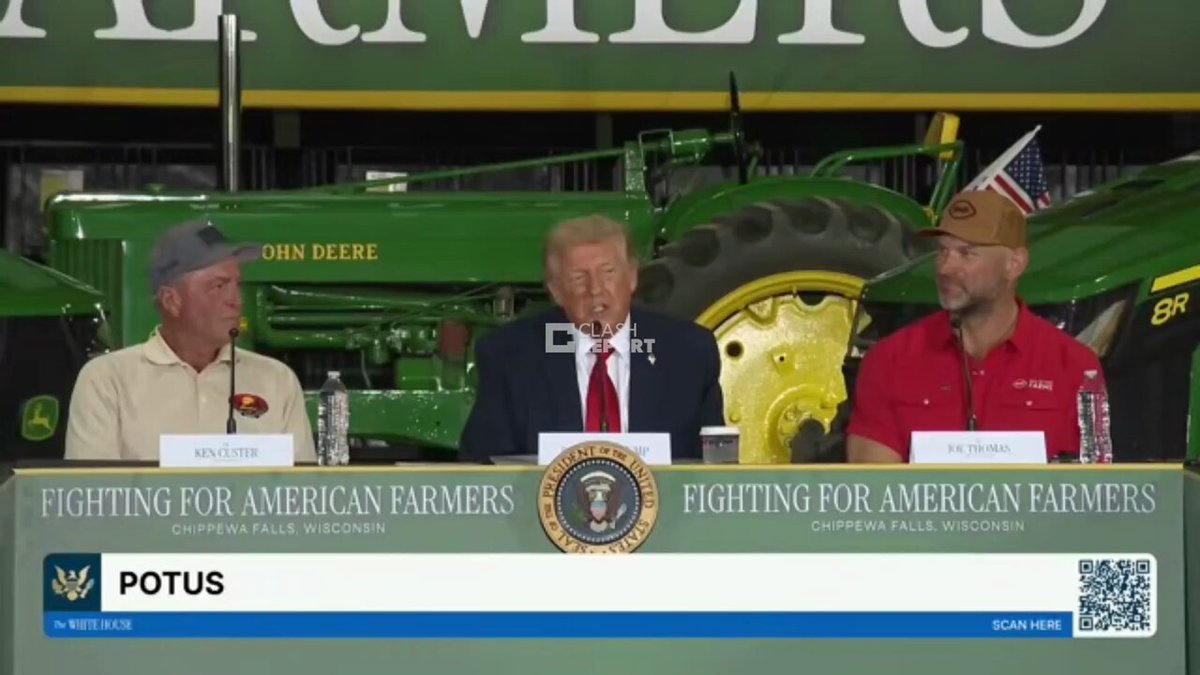 The image shows a group of people sitting at a table, with three men wearing hats and one man wearing a tie. They are seated behind a podium, which has a banner that reads "BREAKING: IRAN FIRES MISSILES AT US BASES! THE USA BOMBS THE HORMUZ RADARS NASDAQ DOWN 4 PERCENT, GOLD DOWN 2.7PERCENT, BITCOIN UNDER 61,000 I'M ORDERING THE CHAOS FOR YOU - Let's Go!". The people are engaged in a discussion or meeting related to the Iranian situation and its impact on various aspects of life.