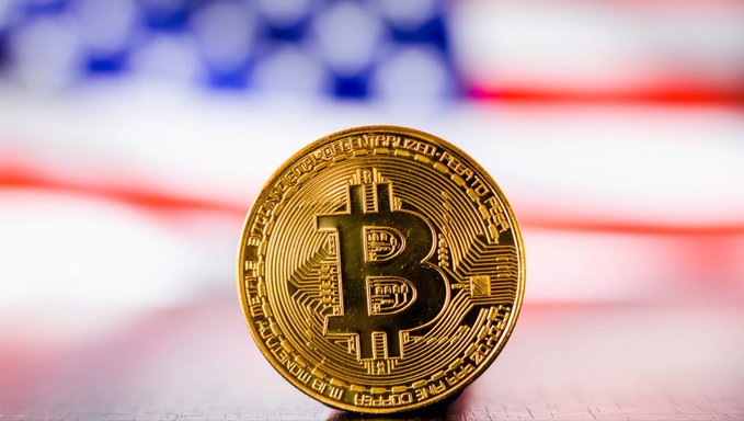 A gold Bitcoin coin with the "B" symbol stands prominently in the foreground against a blurred American flag backdrop, symbolizing the intersection of cryptocurrency and U.S. policy as the House Ways and Means Committee passes the crypto tax bill 38-5.