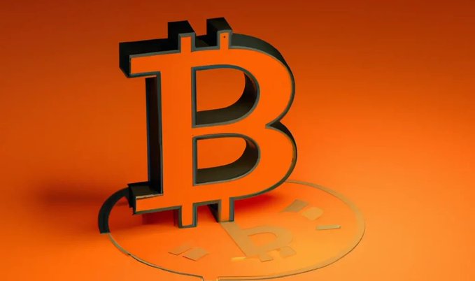 A 3D orange Bitcoin symbol stands prominently against a matching orange background, with its iconic "₿" logo reflected on the glossy surface below. The image visually represents the cryptocurrency at the center of the "Bitcoin Red Team" AI security review, which analyzed 501 open-source Bitcoin projects and identified nearly 8,000 potential vulnerabilities.