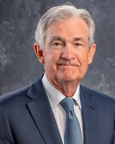 A portrait of an older man in a blue suit and patterned blue tie, appearing to be an official photograph.