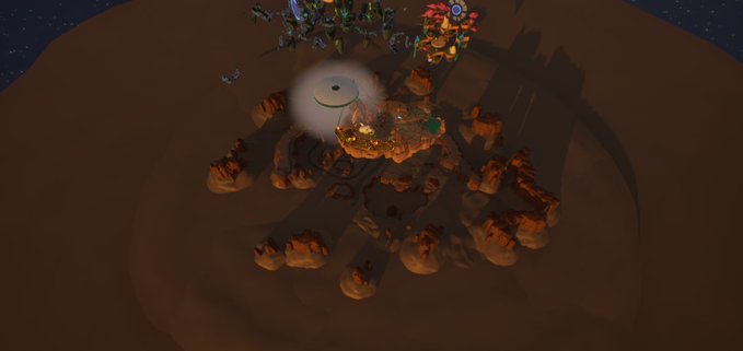 A dark, top-down view of a video game or digital scene featuring small character figures gathered around a glowing campfire surrounded by rocks on a brown terrain.