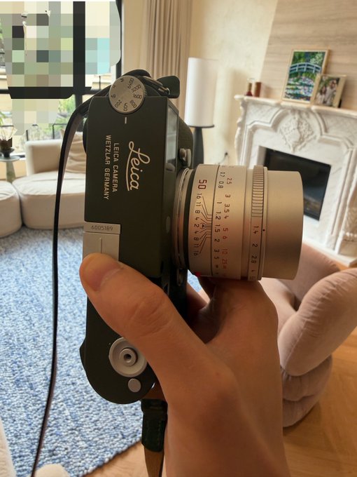A hand holds a black Leica camera featuring a "50/1.4" lens and "WETZLAR GERMANY" branding, with the top dial visible showing shutter speed markings. The image directly illustrates the post's claim about acquiring a "limited edition Leica M11p+50 1.4" for "14000u."