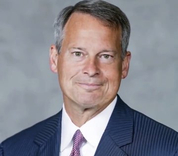 A professional headshot shows a gray-haired man in a dark pinstripe suit and purple patterned tie, identified as Charles Schwab's Head of Digital Assets. The accompanying post highlights his prediction that the CLARITY Act will pass before Congress's August recess, positioning his expertise to underscore the imminent regulatory clarity for digital assets like XRP.