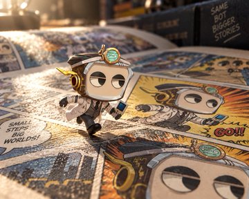 A small figurine of a character in goggles and an aviator outfit standing on an open comic book with text bubbles reading 'SMALL STEPS TO GREAT WORLDS!' and 'GOT!'.