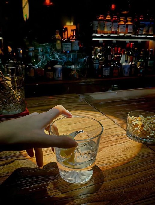 A hand reaches for a whiskey glass on a wooden bar, with curled smoke and a bowl of peanuts nearby, evoking a relaxed evening of thoughtful reflection. This fits the post's theme of slowing down to thoughtfully evaluate projects like QuipNetwork and TermMaxFi rather than rushing to chase every new trend.