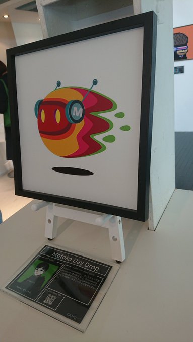 A framed print of the Motoko Ghost character from Metaverse Monstars (Motoko Day Drop) is displayed on a small easel with an information placard, showcasing a physical collectible option among the digital 2D and 3D versions referenced in the post.