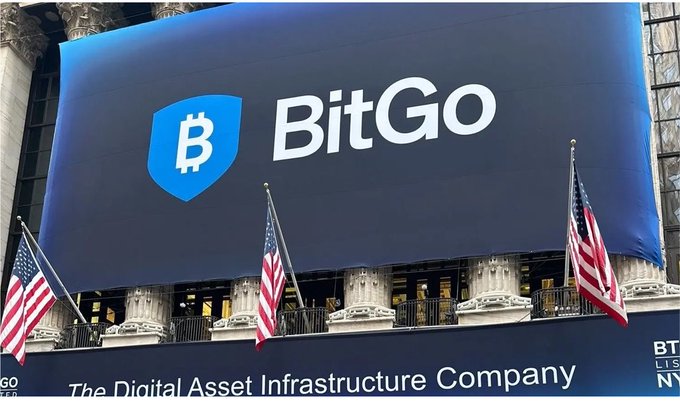 A blue banner displaying the 'BitGo' logo and the text 'The Digital Asset Infrastructure Company' hanging on a building adorned with American flags.