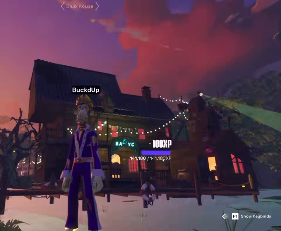 The image shows a man standing in front of an old house, with a purple suit and crown on his head. The man appears to be dressed as a king or queen from a video game. There are two other people visible in the scene, one near the center and another towards the right side of the image. A banner is displayed above the house that says "@OthersideMeta".